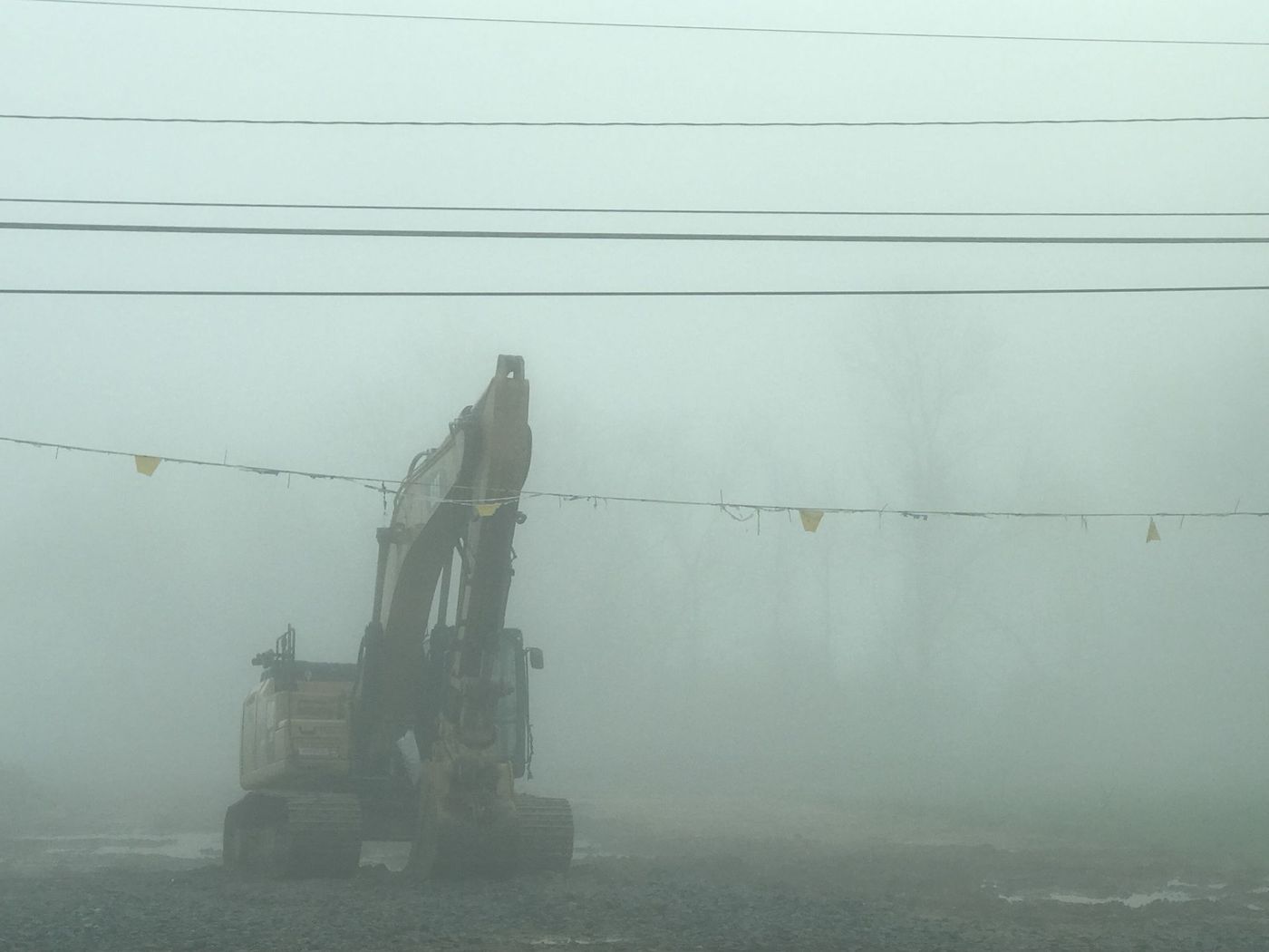 Excavator on a foggy site at the start of a project