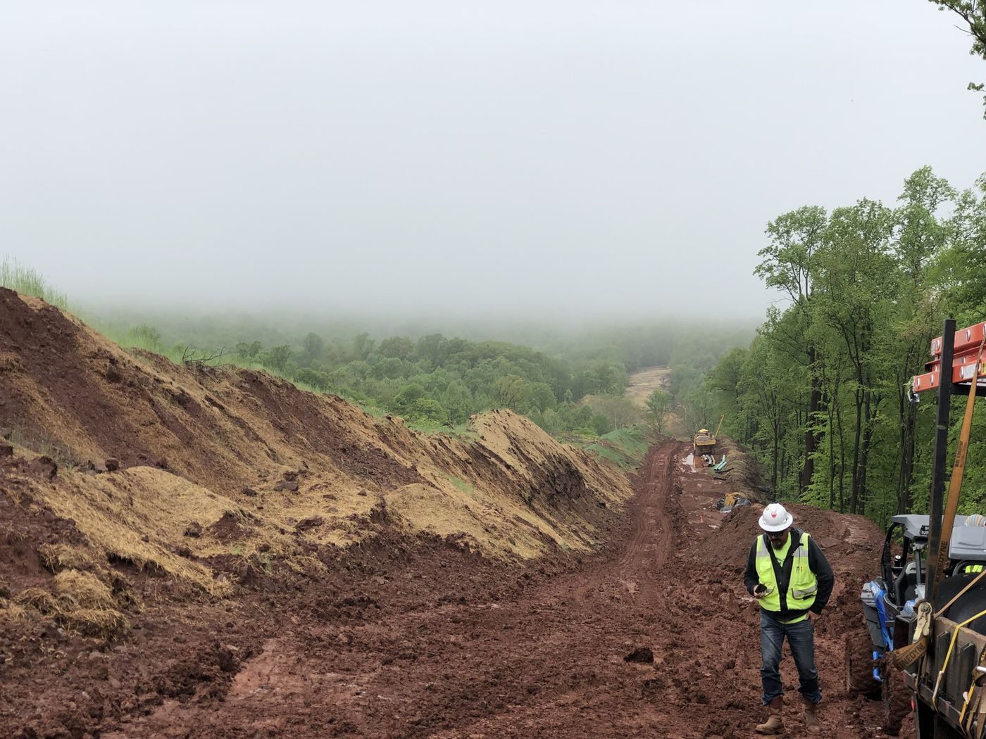 Inspector walking a pipeline right-of-way in fog